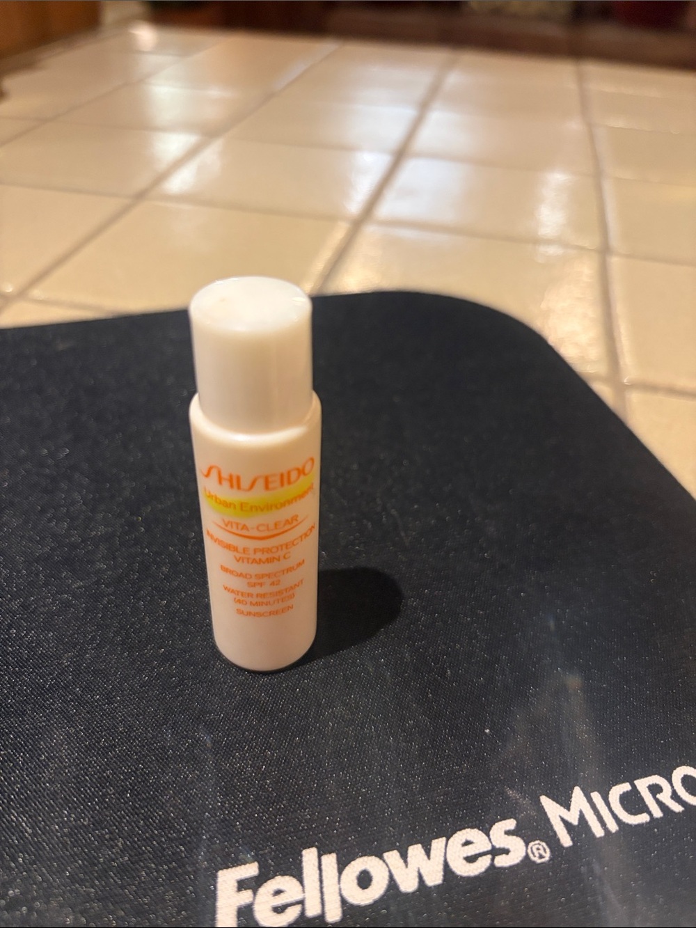 Shiseido White Travel Sunscreen Bottle with Orange Logo